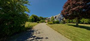 un chemin de gravier devant une maison dans l'établissement Domaine De Kereven, à Bénodet