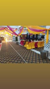GangānagarにあるGovind Guest Houseのカラフルなカーテン、テーブル、椅子が備わる客室です。