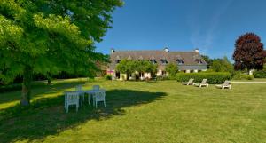 a yard with tables and chairs and a house at Domaine De Kereven in Bénodet