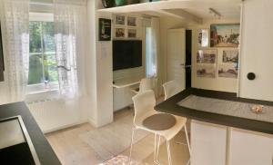 uma cozinha com cadeiras brancas e um balcão preto em Ögränd 2 - Nyrenoverad toppmodern lägenhet em Sveg