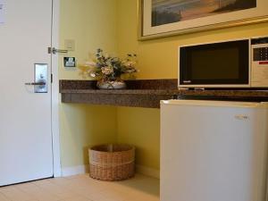 a kitchen with a microwave on top of a refrigerator at Pier 4 Hotel in Somers Point