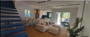 a living room with a couch and chairs and a table at maison avec piscine in Guéthary