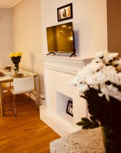 a living room with a fireplace with a table and a mirror at Super Apartment in Kensington Next To Hyde Park in London