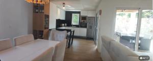 a living room with a table and chairs and a kitchen at maison avec piscine in Guéthary