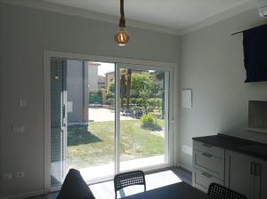 a kitchen with a sliding glass door to a yard at Lucca&Joy Apartment in Lucca