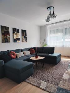 sala de estar con sofá azul y mesa en Spacious and Modern Apartment in Town Center, en Konjic