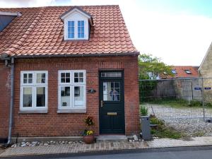 a red brick house with a black door at Det lille hus in Middelfart