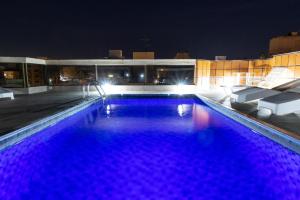 een groot zwembad 's nachts met paarse verlichting bij Ilhasul Hotel Residencia in Florianópolis