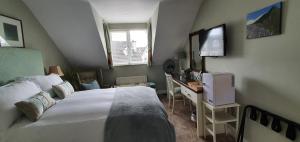 a bedroom with a bed and a desk with a television at Grove Bed & Breakfast in Coleraine