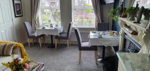 a restaurant with two tables and chairs in a room at Grove Bed & Breakfast in Coleraine