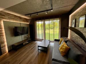 uma sala de estar com um sofá e uma televisão em Loft Klonowa - Apartament z garażem em Kielce
