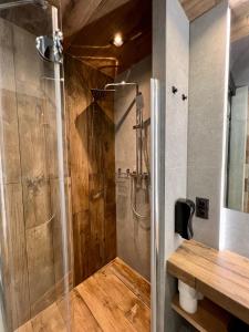 prysznic ze szklanymi drzwiami w łazience w obiekcie Loft Klonowa - Apartament z garażem w Kielcach