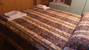 a bed with a quilt on top of it at Lo chalet sui NEBRODI in CastellʼUmberto