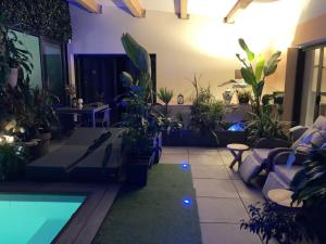 ein Wohnzimmer mit Pflanzen und einem Pool in der Unterkunft Desirad in La Clisse