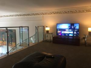 a living room with a large flat screen tv at Perfect In The Park in Glasgow
