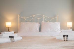 a bed with white sheets and pillows and two lamps at Sydney Wharf House in Bath