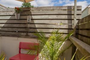 a red bench sitting next to a wooden fence at Sydney Wharf House in Bath +30 photos