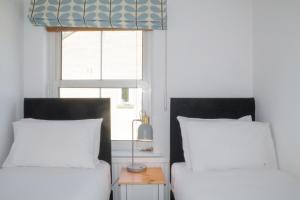 a bedroom with two beds and a window at Sydney Wharf House in Bath