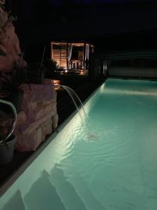 ein Schwimmbad in der Nacht mit einem Springbrunnen in der Unterkunft Desirad in La Clisse