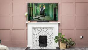 een open haard met een televisie erop bij Grand Apartment in Historic Building with Free Parking in Kent