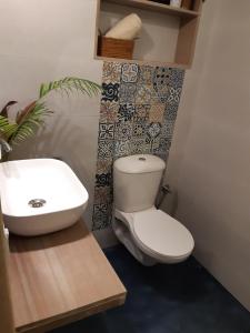 a bathroom with a toilet and a sink at Palm Grove 1 Bhk Apartment at Candolim Beach with free Wifi in Candolim +24 photos