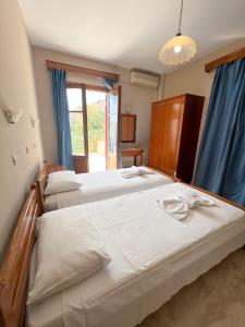 1 dormitorio con 2 camas y ventana grande en Molyvos Stars Apartments en Mithimna