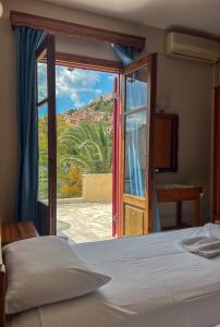 ein Schlafzimmer mit einem Bett und einer offenen Tür in der Unterkunft Molyvos Stars Apartments in Mythimna