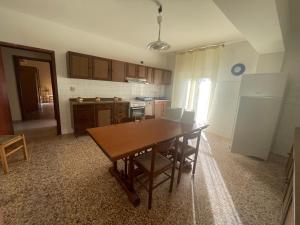 cocina con mesa de madera y comedor en Wind House, en SantʼEufemia Lamezia