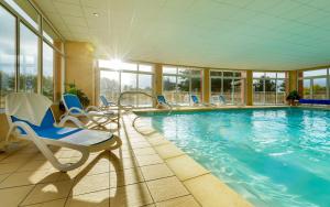 une grande piscine avec des chaises dans l'établissement Lagrange Vacances Cap Green, aux Sables-dʼOr-les-Pins