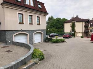 a house with two garage doors and a driveway at Apartamenty pod Jasną Górą in Częstochowa
