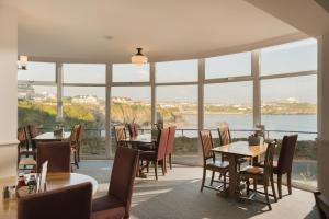 a dining room table with chairs and a large window at Great Western in Newquay