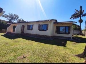 a small house with a grass yard in front of it at Devine Stay- Margate in Margate