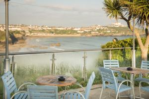 a table and chairs with a view of a beach at Great Western in Newquay