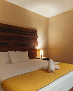 a bed with a white comforter and pillows on it at Hotel Sur Bacalar in Bacalar