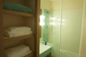 a bathroom with a shower and a sink and towels at Résidence Pierre & Vacances Ty Mat in Saint Malo