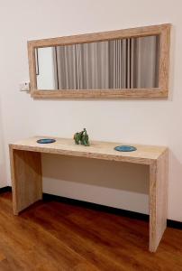 a wooden table with a mirror on a wall at NINETY-NINE APARTMENTS in Kurunegala