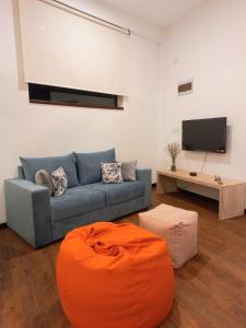 sala de estar con sofá azul y TV de pantalla plana en NINETY-NINE APARTMENTS, en Kurunegala