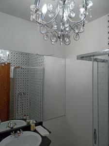 een badkamer met een wastafel en een kroonluchter bij Alojamientos Villarias Archena 43 in Archena