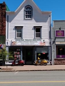 duas scooters estacionadas em frente a uma casa de cura em Healing Touch Holistic Living Space em Amherst