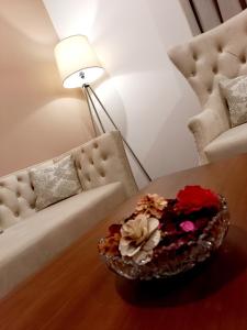 una sala de estar con sofá y un plato de flores en una mesa. en NINETY-NINE APARTMENTS, en Kurunegala