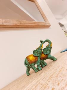 a figurine of two elephants on a shelf under a mirror at NINETY-NINE APARTMENTS in Kurunegala