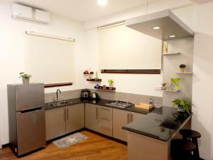 uma cozinha com um lavatório e um frigorífico em NINETY-NINE APARTMENTS em Kurunegala