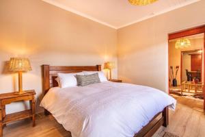 a bedroom with a large white bed with two lamps at Tequila Sunrise Cottage at Karoofontein Guest Farm in Geelwal