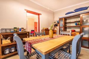 a dining room with a wooden table and chairs at Tequila Sunrise Cottage at Karoofontein Guest Farm in Geelwal
