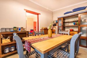 una sala da pranzo con tavolo e sedie in legno di Tequila Sunrise Cottage at Karoofontein Guest Farm a Geelwal