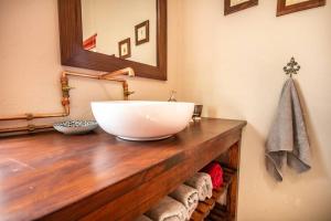 a bathroom with a bowl sink on a wooden counter at Tequila Sunrise Cottage at Karoofontein Guest Farm in Geelwal