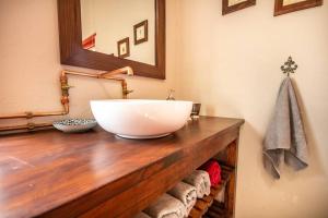 un bagno con lavandino a ciotola su un bancone in legno di Tequila Sunrise Cottage at Karoofontein Guest Farm a Geelwal