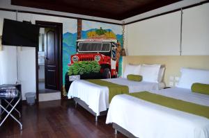 une chambre avec deux lits et une peinture d'un camion dans l'établissement Aromarte Finca Hotel, à Filandia