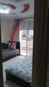1 dormitorio con cama, sofá y ventana en superbe apparemment avec balcon parking gratuit, en Agadir