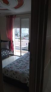 1 dormitorio con 1 cama y puerta con ventana en superbe apparemment avec balcon parking gratuit, en Agadir